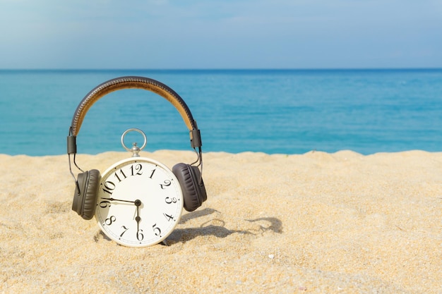 Foto reloj en la playa por el mar contra el cielo