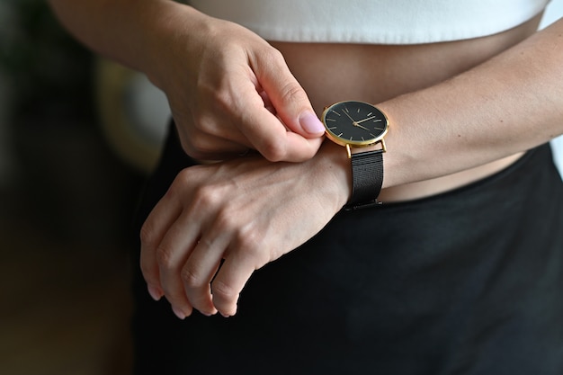 Foto reloj de pulsera dorado para mujer en la mano de la niña