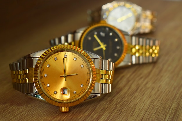 Reloj de pulsera elegante, colocado sobre un piso de cristal brillante