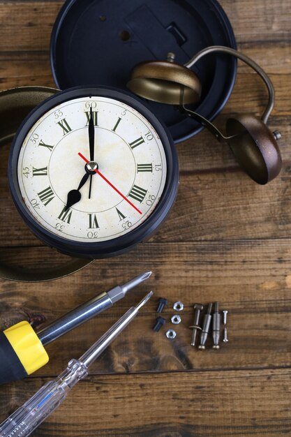 Foto reloj de reparación sobre fondo de madera