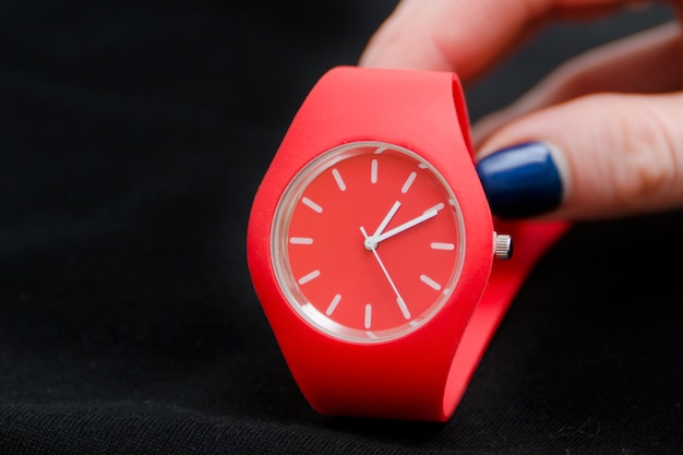 Reloj rojo en una mano femenina