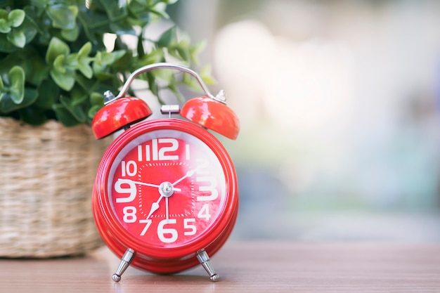 Reloj rojo en mesa de madera