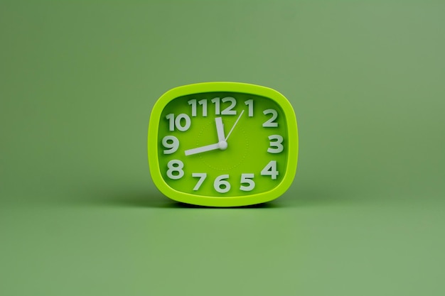 Reloj verde sobre un concepto de fondo verde del tiempo Planificación del tiempo