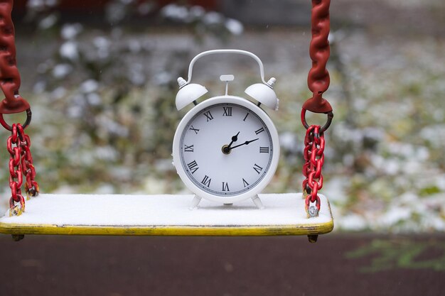 Reloj vintage blanco en un columpio