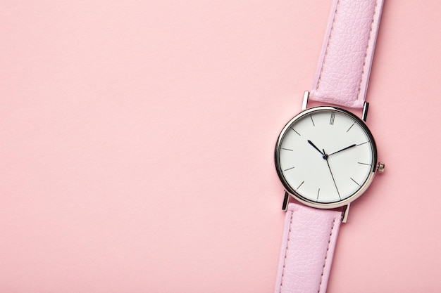 Relojes de pulsera rosa sobre fondo rosa con espacio de copia