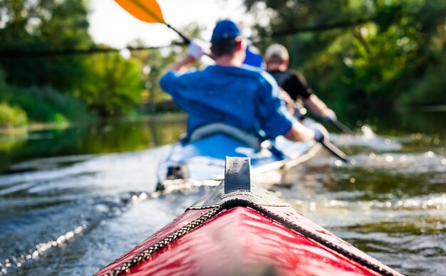 Foto remadores en canoa flotando hacia la orilla