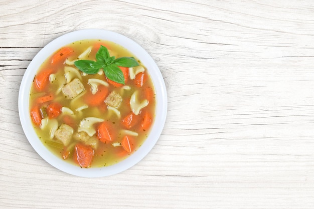 Remédio de sopa de macarrão de galinha em fundo de madeira branco moderno com espaço de cópia