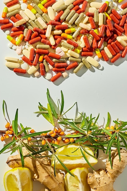Remedios alternativos y pastillas tradicionales para tratar los resfriados y la gripe sobre fondo blanco.