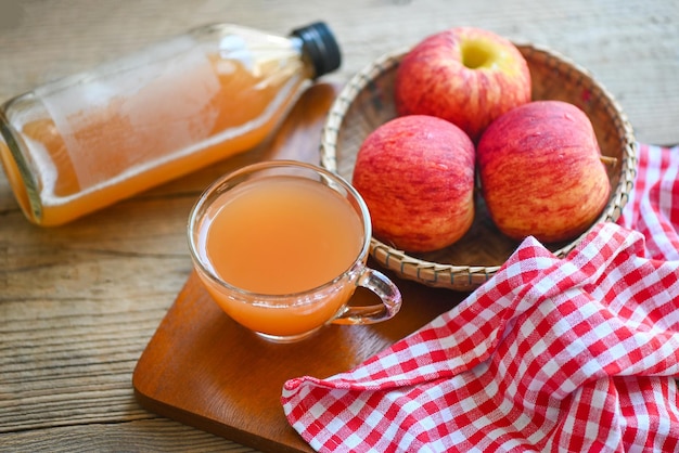 Remedios naturales de vinagre de sidra de manzana y curas para condiciones de salud comunes Vinagre de sidra de manzana orgánico crudo y sin filtrar en vidrio con fruta de manzana en la cesta sobre la mesa de madera