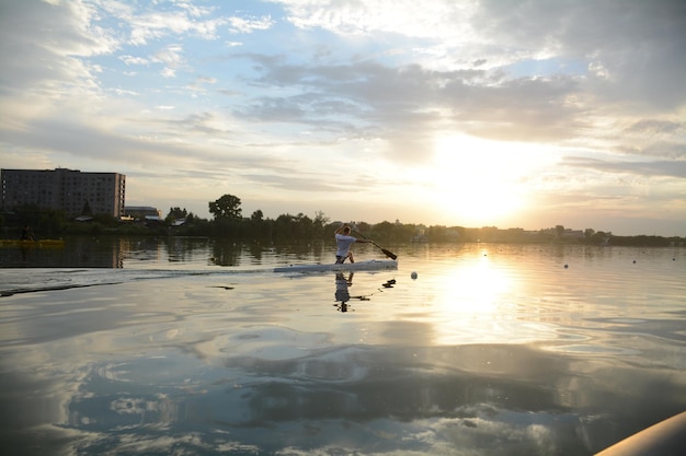 un remero, un piragüista, remando en el río al atardecer. kayak y canoa,