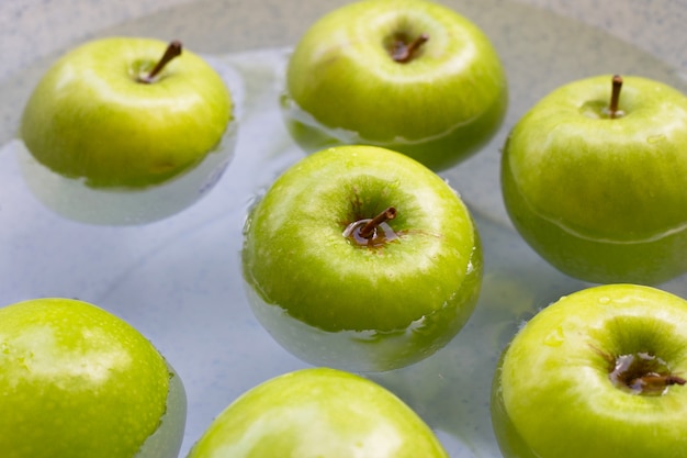 Remojar las manzanas verdes en agua. Concepto de lavado de frutas