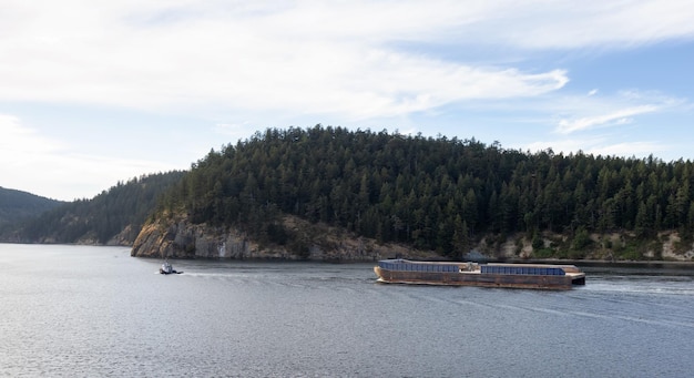 Remolcador en el paisaje canadiense por el océano y las montañas