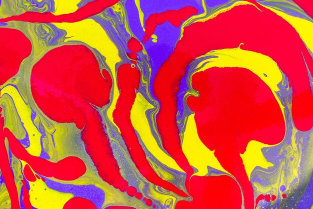 Remolinos rojos sobre ondas amarillas y violetas. Fondo abstracto o textura. Arte fluido acrílico.