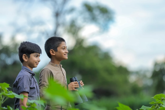 Remolque niño indio disfruta en la naturaleza con binoculares