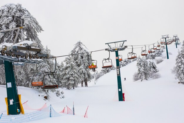 Los remontes y los teleféricos de las montañas de Troodos suben por la montaña y llevan a los practicantes de snowboard a las pistas de esquí