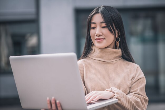 Remote-Arbeiten. Eine asiatische junge Frau mit einem Laptop