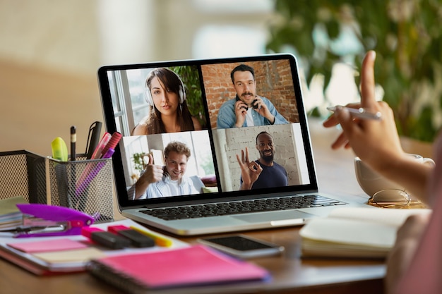 Remote-Meeting. Frauen, die während der Quarantäne von Coronavirus oder COVID-19 von zu Hause aus arbeiten, Remote-Office-Konzept. Junger Chef, Manager vor Monitor während Online-Konferenz mit Kollegen und Team.