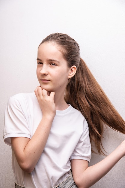 Remover marcas de nascença no rosto menina tocando cabelo grosso e saudável desviar o olhar vestindo camiseta branca