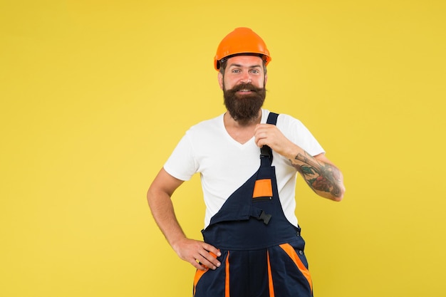 La renovación importante pone un fuerte énfasis en los materiales naturales y la sostenibilidad Mejora y renovación Constructor de hombre brutal Uniforme de constructor de hombre Casco de constructor de hombre Creatividad y práctica