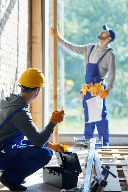 Renovar su casa joven ingeniero que trabaja en el sitio de construcción de la cabaña que recoge el instrumento de