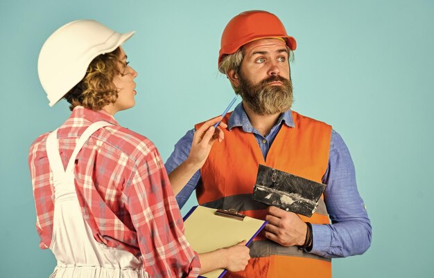 Foto renovierung mit auftragnehmer besprechen paar plant änderungen renovierungswohnung renovierungskonzept vertrag mit arbeitern unterzeichnen preisliste paar sieht dokumente frau und mann schutzhelm