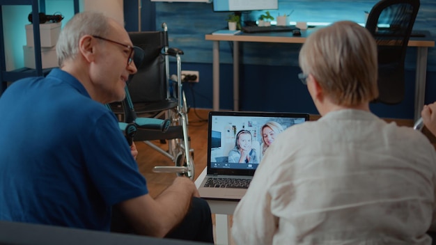 Rentner, die an einem Online-Meeting mit Tochter und Nichte auf einem modernen Laptop teilnehmen. Großeltern nutzen Remote-Videokonferenzanrufe, um sich mit der Familie zu unterhalten, für die Telekommunikation.