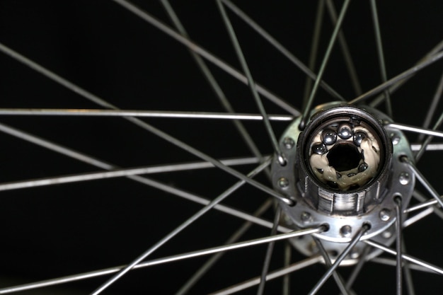 Reparação de bicicletas Limpeza e substituição de graxa no cubo traseiro da bicicleta A roda traseira da bicicleta em um fundo preto Os raios e os cubos são cinza Freehub close-up Instalando novos rolamentos