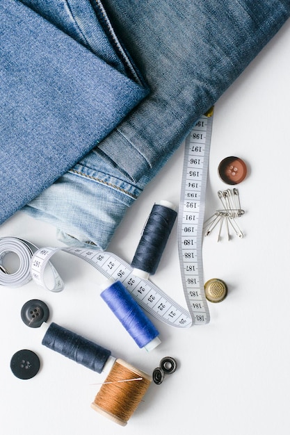 Reparação de roupas artesanais Jeans rasgados acessórios de costura fundo branco O conceito de coisas econômicas