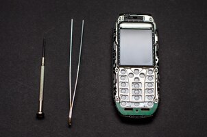 Reparação de telefones celulares e vários aparelhos eletrônicos um antigo telefone de botão na mesa do engenheiro