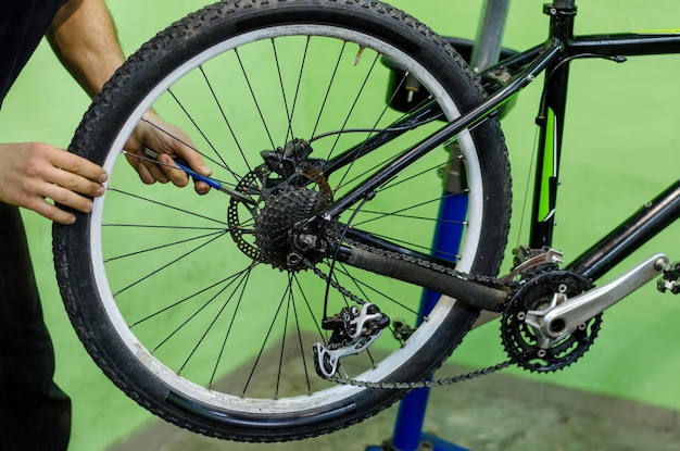 Foto reparación de bicicletas bicicleta de montaña en el taller ajuste del freno de disco trasero