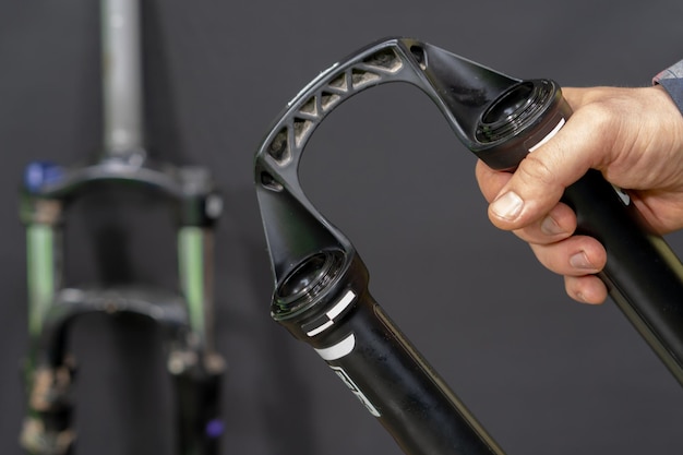 Reparación de bicicletas de montaña modernas y horquillas amortiguadoras en un taller profesional Las partes de la horquilla están cerradas sobre un fondo negro Mantenimiento de bicicletas antes de las competiciones