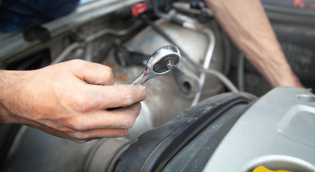 Reparación de coche mecánico con llave de trinquete.