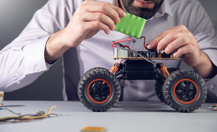 Foto reparación de hombre de un juguete de coche de batería