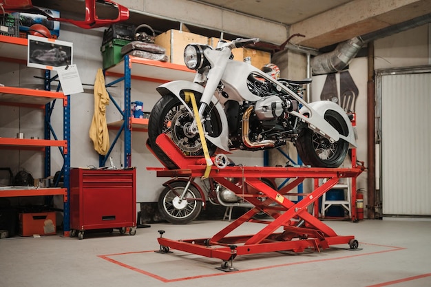 Foto reparación de motocicletas personalizadas de pie en el taller de reparación instrumentos y equipos pasatiempos y trabajos únicos