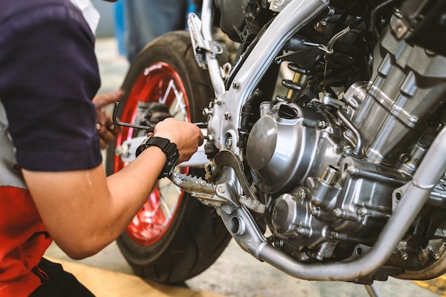 Foto reparación de motor de motocicleta con enfoque suave y luz en el fondo.