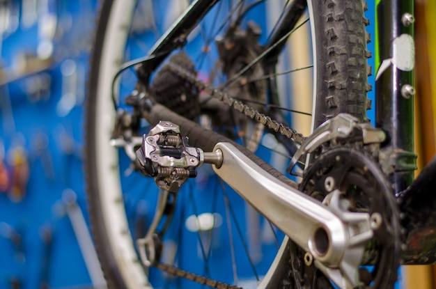 Reparación profesional de bicicletas de montaña Preparación para la competencia Bicicleta en el fondo del tablero con herramientas Rueda trasera de cerca