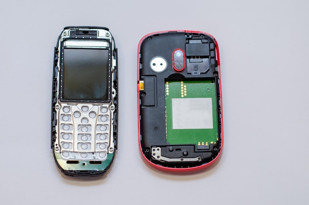 Reparación de teléfonos móviles y varios aparatos electrónicos Un teléfono con pantalla rota en el escritorio del ingeniero Pinzas y un destornillador en la mesa