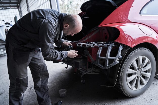 Reparación de trabajador de servicio de coche restaura coche