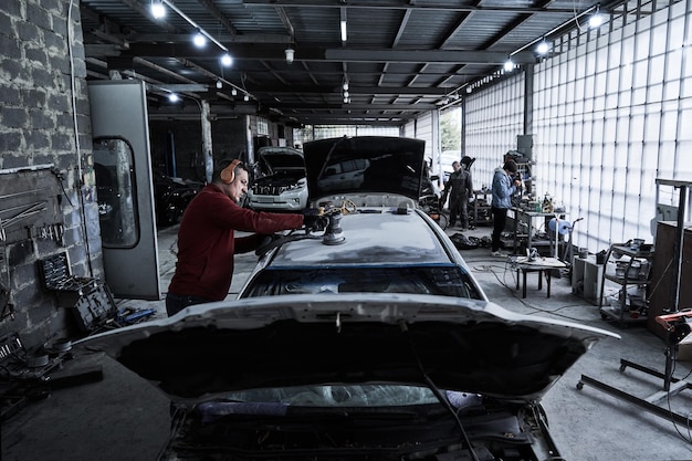 Foto reparación de trabajador de servicio de coche restaura coche