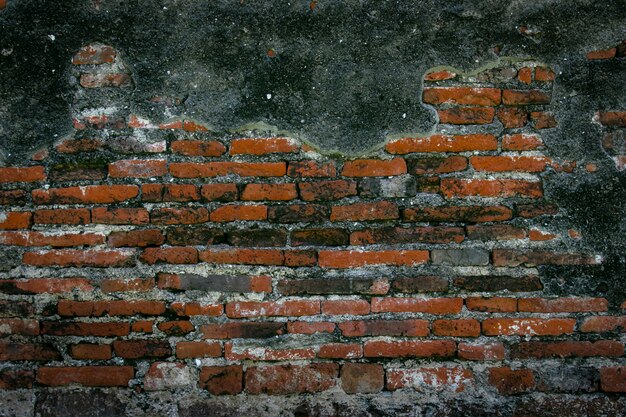 Reparación vieja de la pared de ladrillo rojo del vintage por el cemento, fondo de la textura de la pared de ladrillo de la grieta