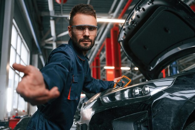 El reparador de automóviles está en el garaje con el automóvil