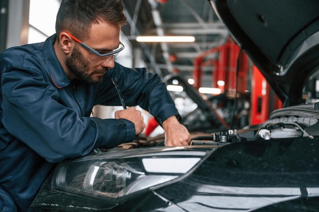 El reparador de automóviles está en el garaje con el automóvil