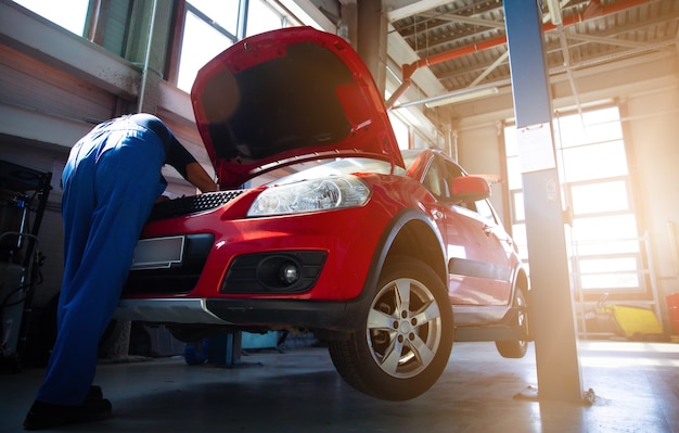 Reparador de automóviles profesional repara un automóvil en una estación de servicio y utiliza herramientas especiales