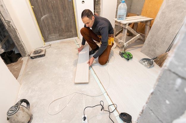 Reparador colocando piso laminado em casa.