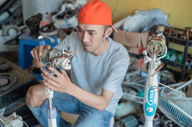 reparador conserta um dínamo de ventilador quebrado