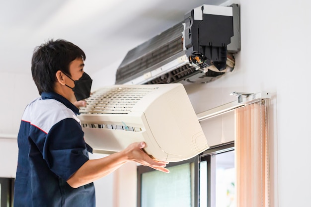 Foto reparador consertando ar condicionado moderno técnico masculino limpando ar condicionado dentro de casa conceitos de manutenção e reparação