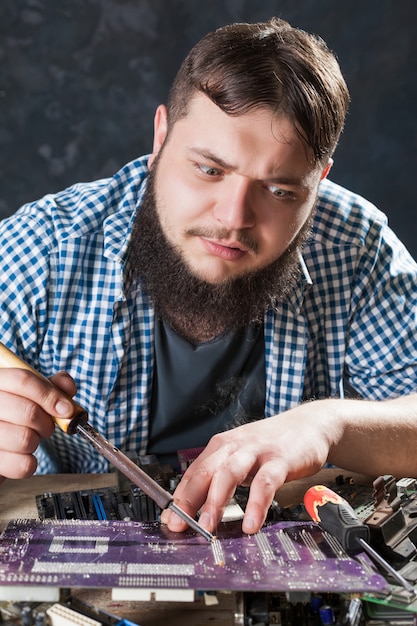 Foto reparador corrigindo problema com ferramenta de solda