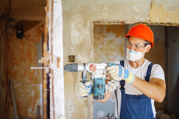 Reparador de macacão segurando ferramentas Reparação de apartamentos e conceito de renovação Edifício