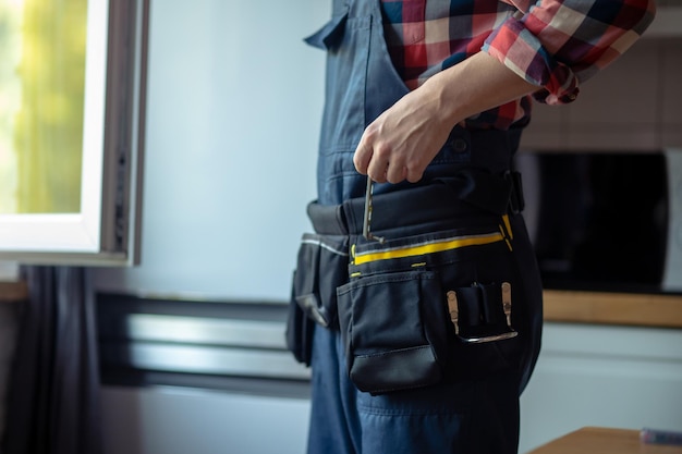 Reparador experto que se prepara para arreglar una ventana de la cocina