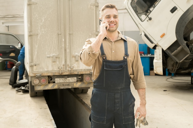 Reparador feliz hablando por teléfono